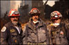 Photo of three rescue workers in front of the World Trade Center site.