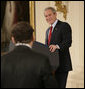 President George W. Bush smiles as he responds to a writer's question Wednesday, Feb. 14, 2007, during a press conference in the East Room of the White House. The President covered many topics including international issues and bipartisan opportunities. White House photo by Eric Draper