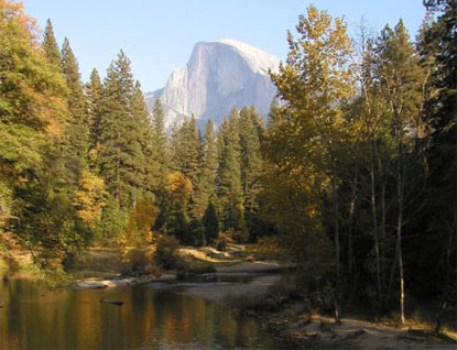Half Dome looms over the Merced River amidst fall foliage
