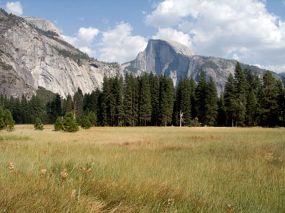 Half Dome; clouds in background, browning grass in foreground