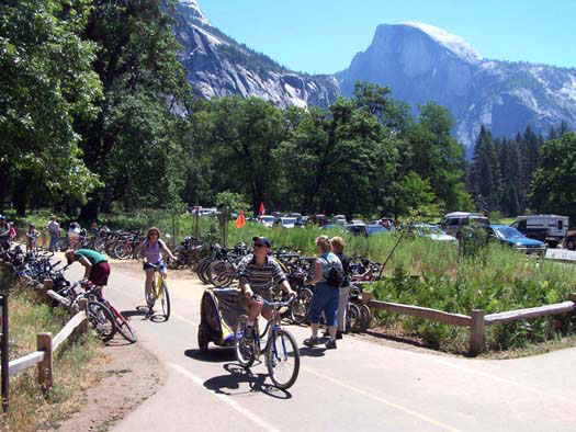 Bicyclists riding down bike path with Half Dome in background
