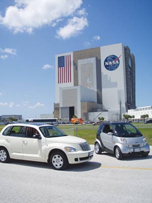 Two of Hybrid Technologies’ electric vehicles are displayed in front of Kennedy Space Center.