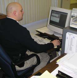 Photograph of police officer using a desktop computer