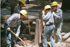 Youth Conservation Corp members work with shovels to create new walkways and trails.