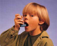 Fotografía de un niño usando un inhalador