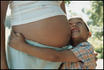 Foto: un niño pequeño con su madre embarazada
