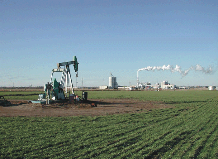 This pumpjack in Hall-Gurney oilfield, together with the ethanol plant in the background near Russell, KS, demonstrates the synergistic environmental and energy benefits of using industrial waste carbon dioxide in a CO2 flood.