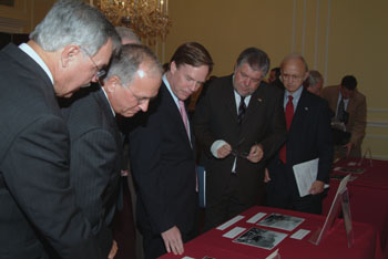 Attendees view the exhibit showcasing U.S. Presidents visits to the Berlin Wall.