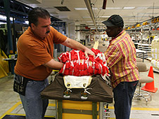 Workers carefully fold parachute