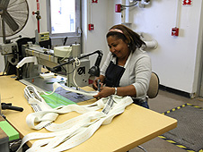 Worker sews parachute straps