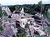 Large stone buildings on top of a grassy hill