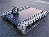 A flat rover with silver-colored tracks similar to those of an army tank