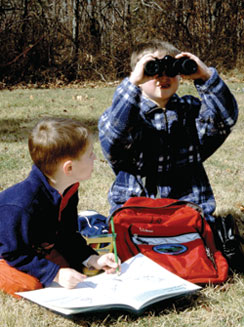 Two young Shenandoah visitors - one with binoculars, the other with a Junior Ranger book.