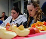 Image of two girls in class with fruit on table