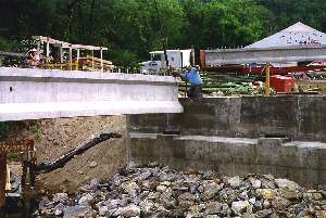 Construction crew emplaces the first high-performance concrete beam of the HPC demonstration bridge over the Newfound River in New Hampshire.