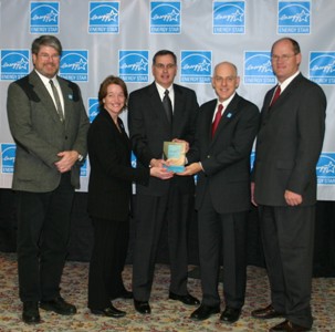 Les Renfrow, DMEA's Board President(c), holds the co-op's ENERGY STAR award, flanked by the US EPA's Kathleen Hogan and the US Department of Energy's David Rodgers. Paul Bony, DMEA Marketing Manager (l) and Dan McClendon, DMEA General Manager (r) complete the quintet.