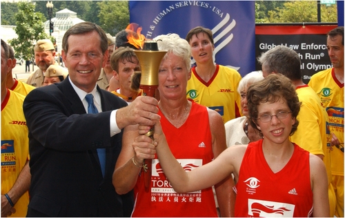 Secretary Leavitt and two athletes hold the Special Olympics World Summer Games Flame of Hope Torch.