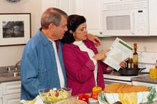 Fotografía de un hombre y una mujer en la cocina leyendo la etiqueta de un alimento
