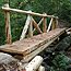 Wooden bridge over a wooded ravine.