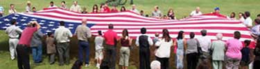newly sworn-in young US citizens and their families raise the garrison flag