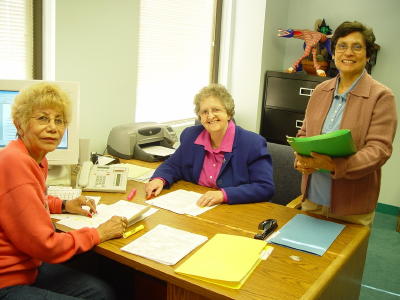 Photo of Sister Therese sitting at her desk with coworkers - 
Copyright 2004 Dr. Carmela G. Lacayo, President/CEO, Asociacion 
Nacional Pro Personas Mayores