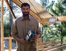 Mohammed Ayaz, from Malot, a town in northeastern Pakistan, received power tools to restart his carpentry business. In return, he is constructing the shelter behind him for a widow who cannot build it herself.