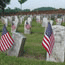 American flags fly next to headstones at Chalmette National Cemetery