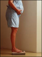 Pregnant woman standing on scale