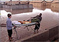 Two Army soldiers remove a bunk from their flooded tent at Kirkuk Air Base, Iraq, Jan. 13. The base was hit by nearly 2 inches of rain overnight, leaving many areas of the base, including tents for airmen and soldiers, deluged with water.