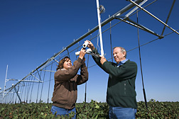 Agricultural engineers adjust the field of view for wireless infrared thermometers mounted on a center pivot irrigation system: Click here for full photo caption.