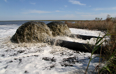 Photo of the rush of salty, muddy, floodwater being pumped out of Bayou Sauvage NWR after Hurricane Katrina