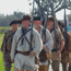 Men dressed as American soldiers from the 1815 Battle of New Orleans march with muskets at Chalmette Battlefield.