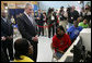 President George W. Bush looks over the shoulders of middle school students as they work on projects for Malaria Awareness Day Friday, April 25, 2008, during his visit to the Northwest Boys & Girls Club in Hartford, Conn. White House photo by Chris Greenberg