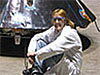 Engineer Jaime Dyk sits in front of a Mars Rover backshell