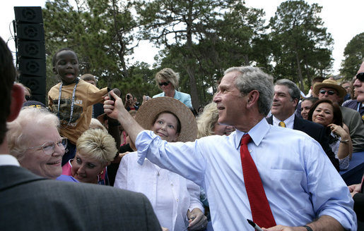 President George W. Bush reaches up to shake the hand of a youngster Tuesday, May 29, 2007, after delivering remarks on comprehensive immigration reform during a visit to the Federal Law Enforcement Training Center in Glynco, Ga. White House photo by Eric Draper
