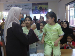 Six-year-old Maja helps her mother draw the winning ticket for a USAID-Adidas soccer ball at the Hope and Life Association in Gaza City.