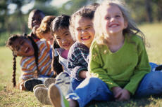 Fotografía de niños sonrientes sentados afuera