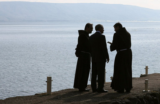 President George W. Bush is accompanied by two friars as he views the Sea of Galilee Friday, Jan. 11, 2008, during his visit to Capernaum before leaving Israel. According to sources, the location was that where Jesus walked upon the water. White House photo by Eric Draper