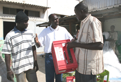 Pape Amadou Sow, center, discusses discarded plastic sources with collectors Cheikh Jone, left, and Mbacké Dieng at his recycling plant in central Dakar.