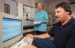 Sharon Horn and  William Miller prepare samples of Campylobacter for DNA analysis. Monitor shows sequence of  DNA sample run earlier. Link to photo information