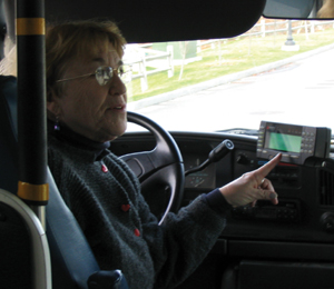 Photo shows driver of a paratransit vehicle utilizing an onboard computer.