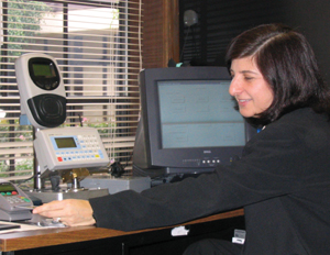 Photograph of a human services agency employee utilizing electronic equipment to add fare to a farecard.