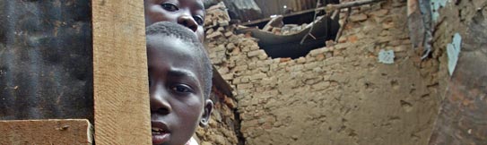 Boys look at the remains of a house hit by a rocket in Bujumbura, Burundi. April 2003. (AP Photo/Karel Prinsloo)