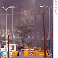 A Yemeni soldier takes position as smoke billows following an attack on the U.S. embassy in Sanaa, 17 Sep 2008 (a handout picture released by the Yemeni Saba news agency)