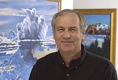 Graeme Stephens stands in front of a painting of large white clouds in a pale blue sky
