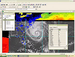 A satellite image of a hurricane coming ashore on the eastern coast of the United States. The image shows cloud layers as well as ultraviolet information in bright colors.