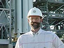 Phil Christensen stands in front of a rocket