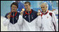 U.S. swimmer Michael Phelps shows off his Olympic gold medal as he stands on the victory podium with teammate Ryan Lochte, bronze medalist, and HungaryÕs Laszlo Cseh, silver medalist, at the National Aquatics Center in Beijing. White House photo by Eric Draper