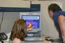 Teacher Tim Spuck and a student look at a computer monitor as she points to the screen