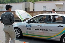 Photo: people looking at a car  that is labeled, "fuel cell vehicle."